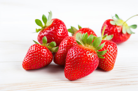 Red ripe strawberries on white wooden background, a Food & Drink Photo by AlyaAnd