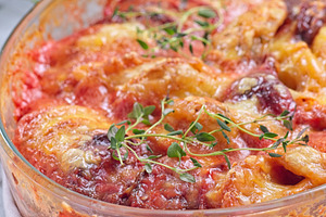 Sweet potato, parsnips and beet root au gratin, in glass dish, vertical, a Food & Drink Photo by iuliia_n