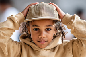Portrait of cute child wearing in wearing a hoodie and a cap, a Person Photo by AlyaAnd