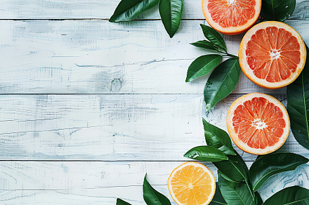 Fresh and tasty grapefruits and green leaves on wooden background, a Food & Drink Photo by AlyaAnd