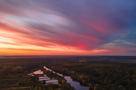 Aerial view of beautiful river and forest landscape with colorful summer sky