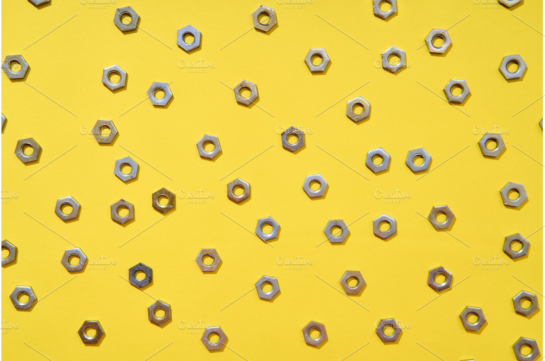Metal nuts pattern on yellow, an Industrial Photo by Gladkov photography