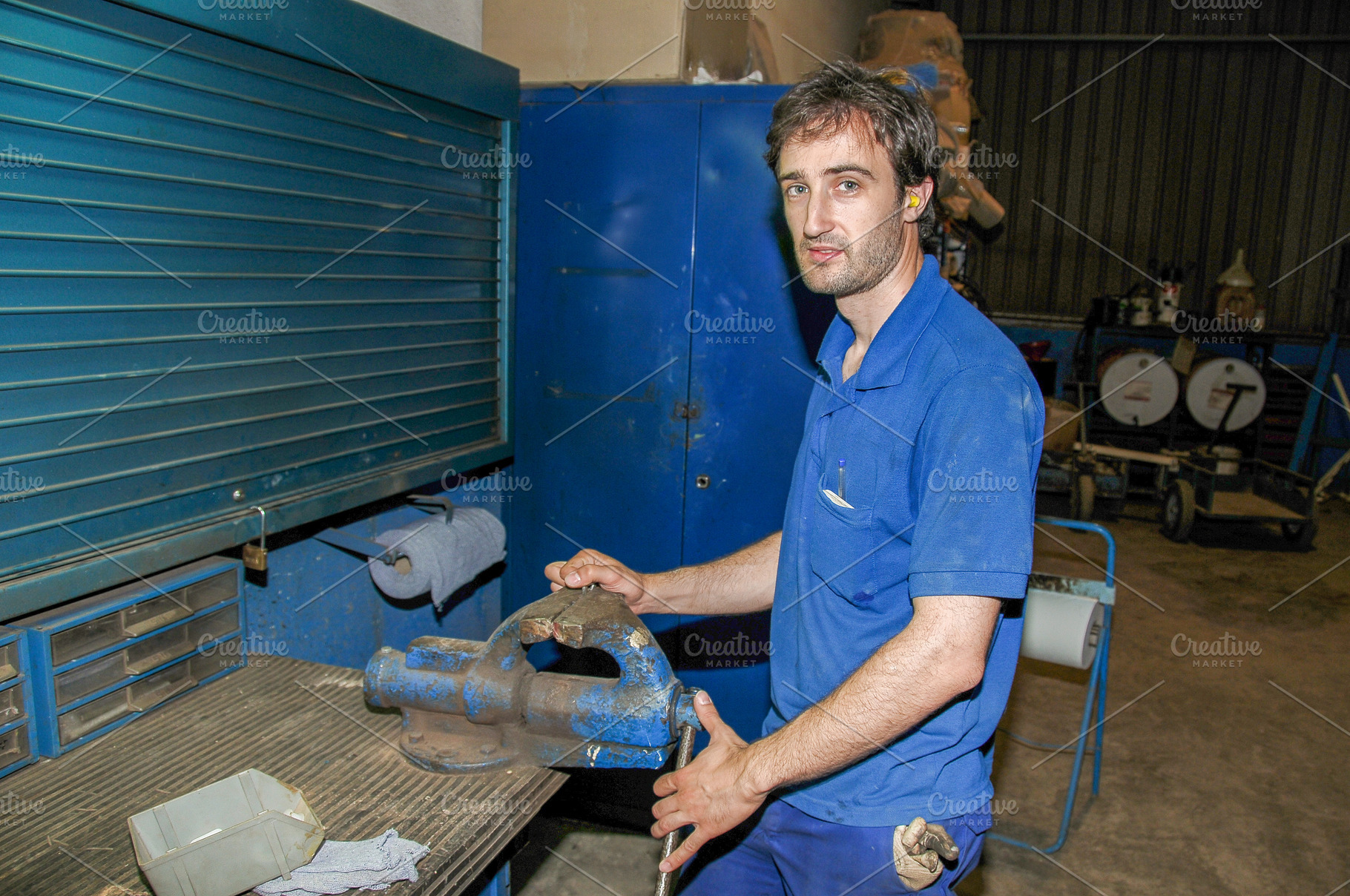 Industrial worker holding metal vise in workshop, an Industrial Photo by Davizro's Market