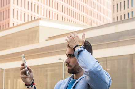Handsome young man smiling when he is using his mobile phone, a Person Photo by RF Images