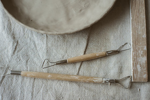 Ceramics in pottery workshop set featuring tools, pottery, and sculpting