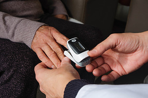 a healthcare worker checking oxygen levels, a Photo by Nito