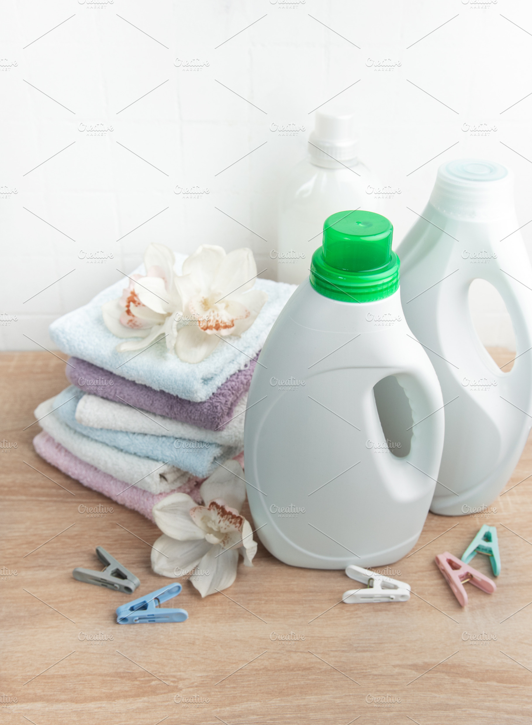 Laundry products with clean towels and orchids on wood, an Industrial Photo by Olena Rudo
