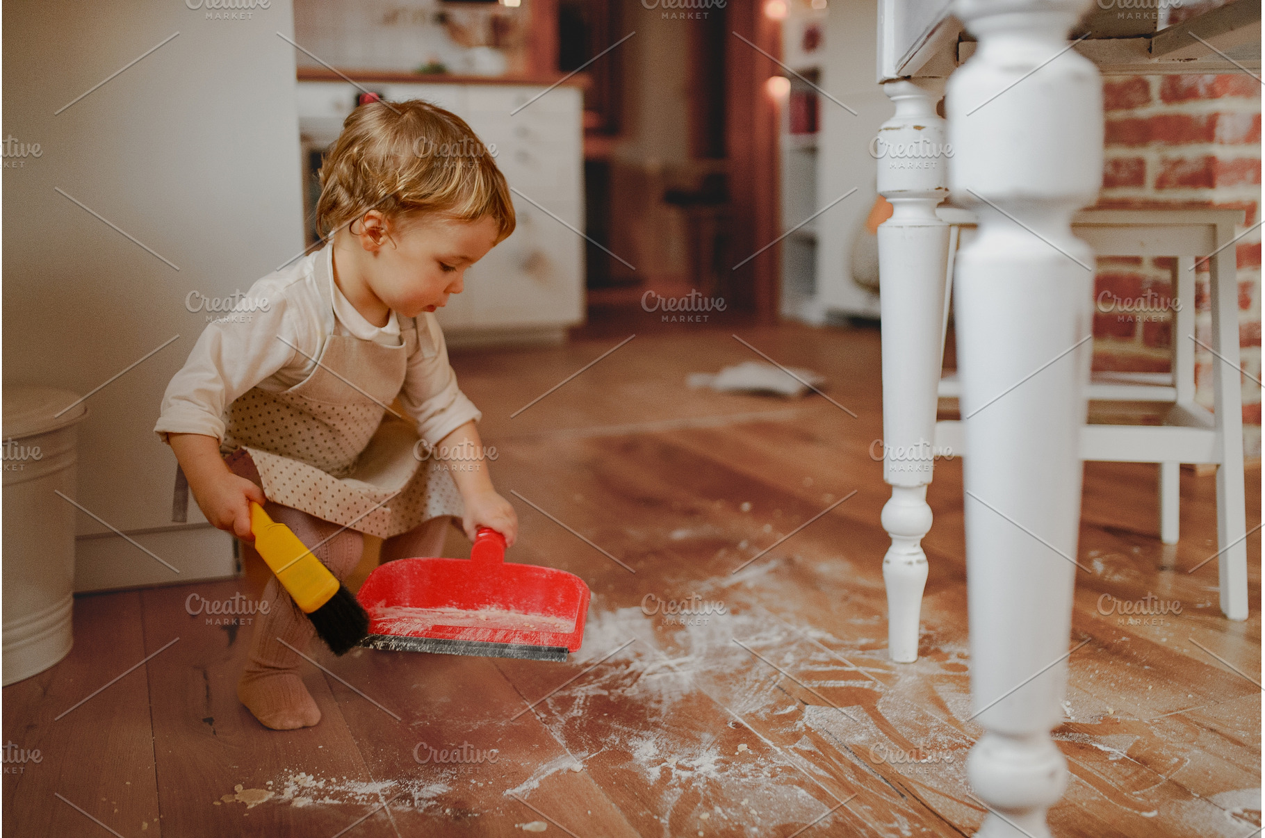 Little girl cleaning up flour mess, a Holiday Photo by HalfPoint
