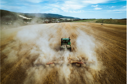 Aerial view of a tractor working in, an Industrial Photo by HalfPoint