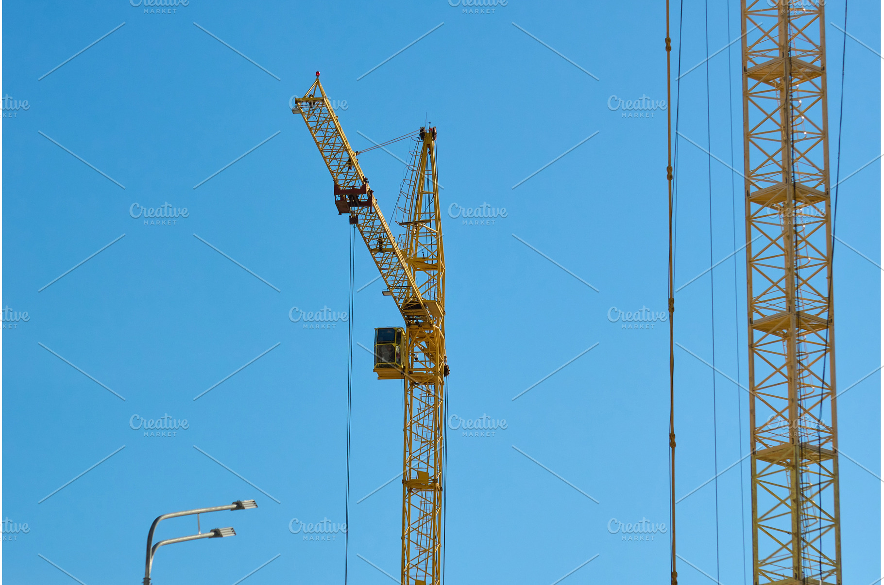 Two tall cranes stand in an urban, an Industrial Photo by darksoul72