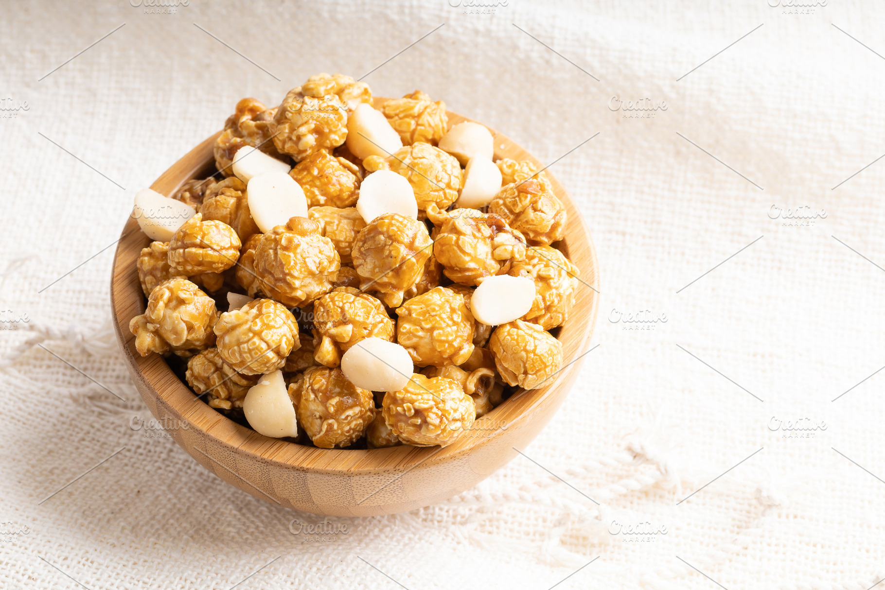 Caramel popcorn with macadamia nut in bamboo wooden bowl, a Food & Drink Photo by Smith Chetanachan