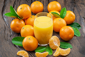 Orange tangerine fruits and glass of fresh tangerine juice on da, a Food & Drink Photo by Volff
