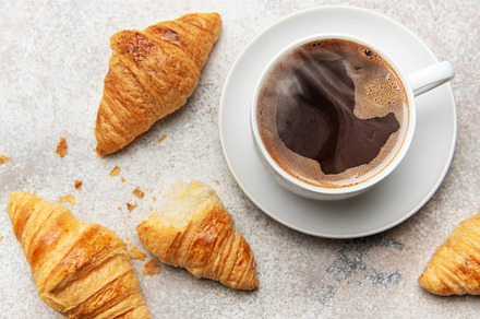 Freshly baked croissants and steaming cup of coffee creating per