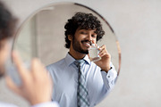 Handsome indian businessman in classic shirt and necktie smelling perfume while, a Photo by Prostock-Studio (Thumbnail 2 of 2)
