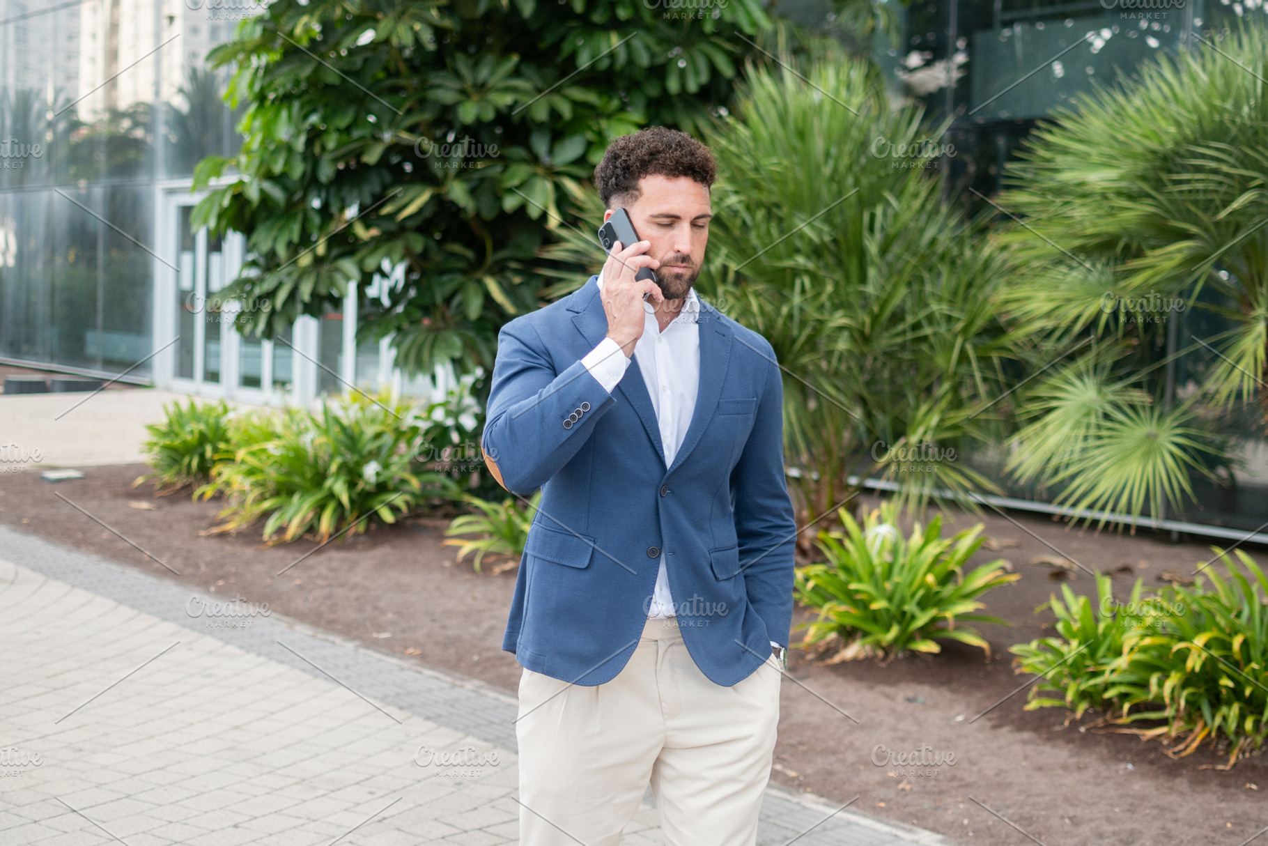 Businessman talking on smartphone while walking outside office, a Business Photo by etorres69