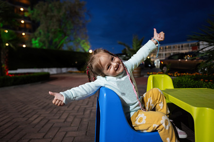 Adorable little girl having fun on a playground in the evening., a Person Photo by AS photostudio