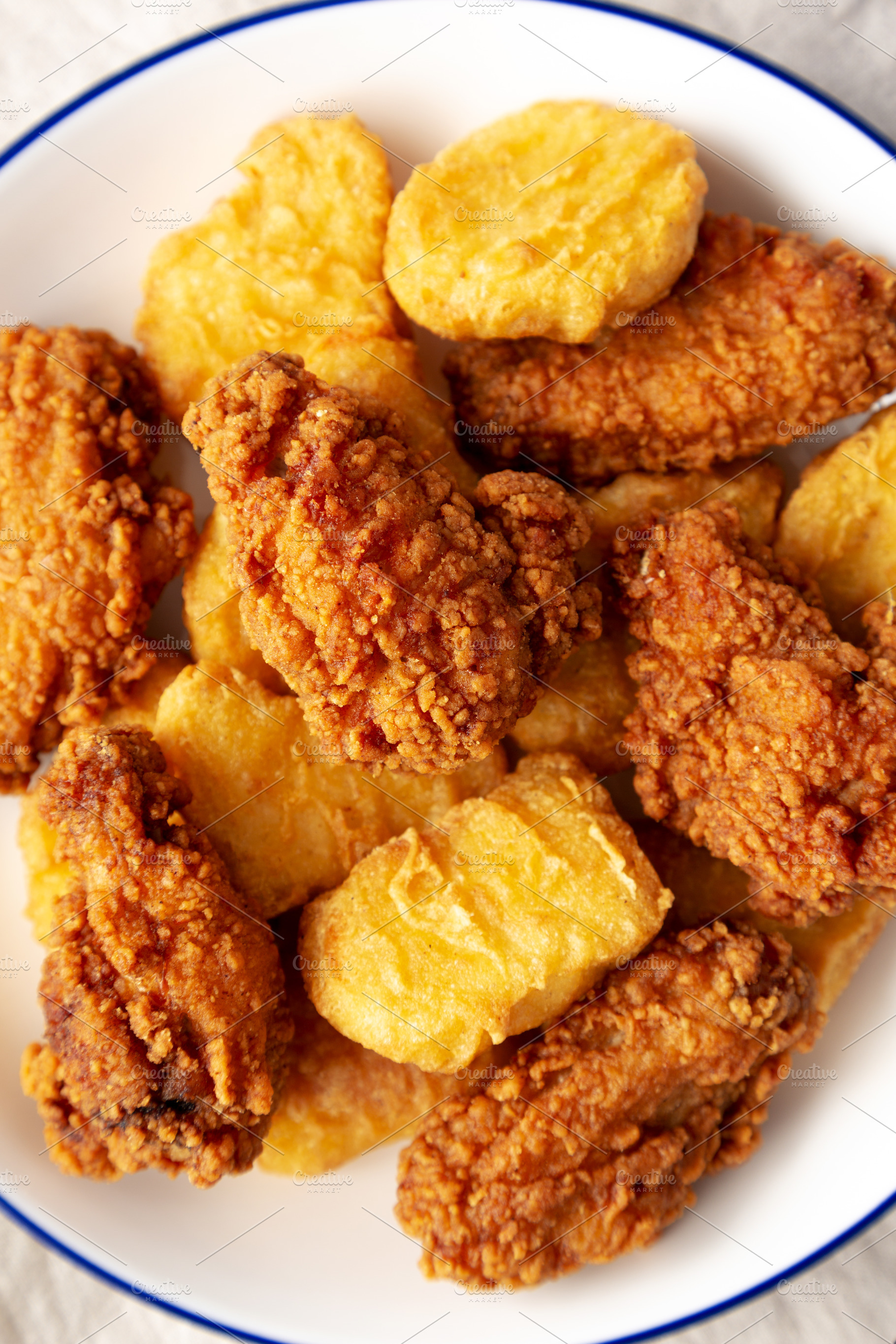 Homemade Chicken Nuggets and Chicken Wings on a Plate, top view., a Food & Drink Photo by LiudmylaChuhunova