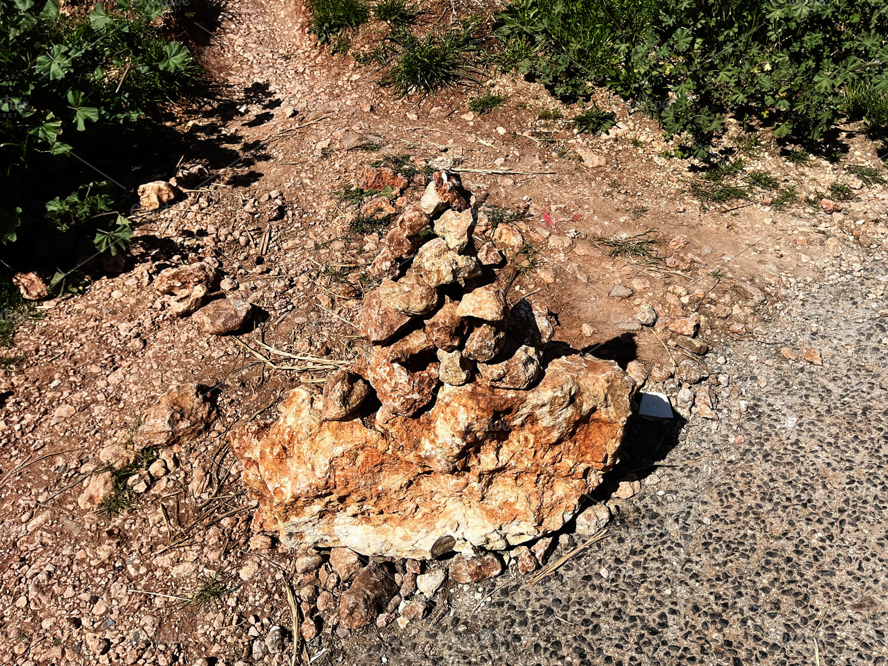 Stacked rocks formation on a trail in Nazare, Portugal under sunlight, a Photo by AS photostudio
