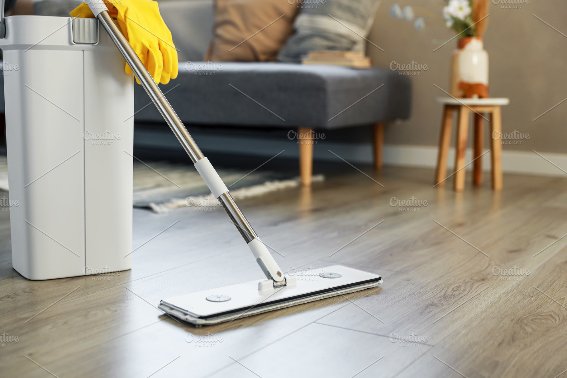 Cleaning supplies: mop, gloves, bucket with wringer on wooden laminate floor, a Business Photo by Lenor4ik