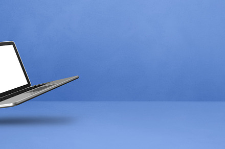 Floating computer laptop isolated on blue. Horizontal banner bac, a Technology Photo by GoodGoods