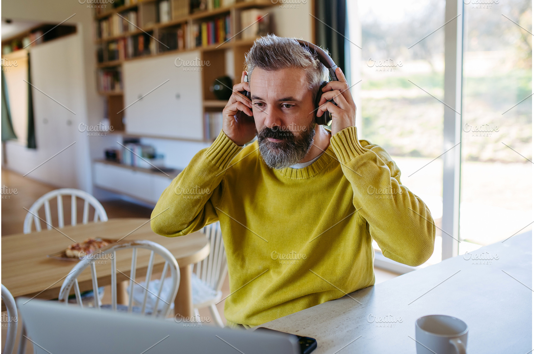 Bearded man listening to music at, a Person Photo by HalfPoint