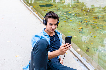 Man listening to music by a pond., a Person Photo by RF Images