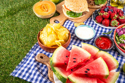 Tasty summer barbecue table with hamburgers, salads, fruits and