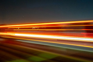Light trails of a moving vehicle at night on the road, a Nature Photo by GoodGoods