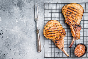 Juicy grilled pork Tomahawk chop, perfectly seared and bursting, a Food & Drink Photo by composter-box@mail.ru