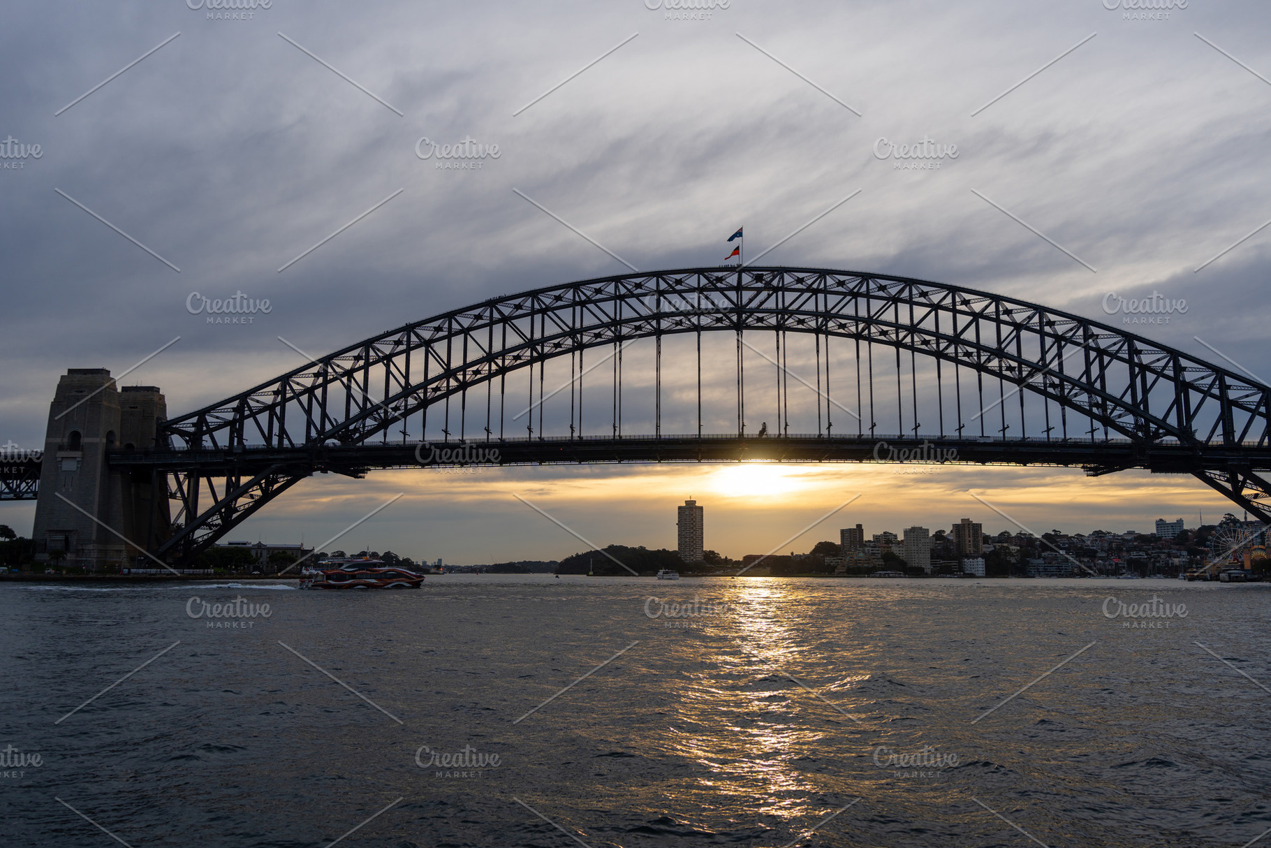 Sydney Harbour Bridge at sunset with golden reflections on the w, an Architecture Photo by GoodGoods