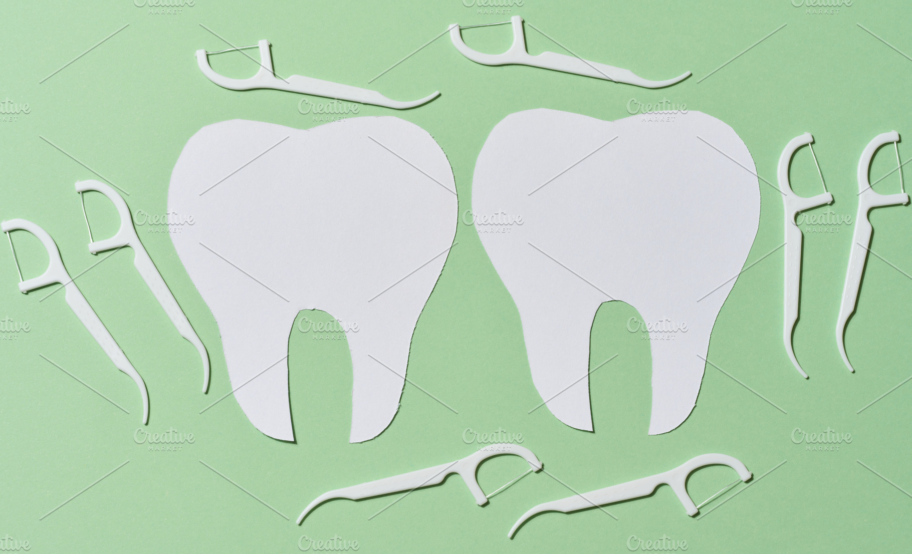Two white paper cutouts of teeth are surrounded by multiple whit, a Health & Medical Photo by ndanko
