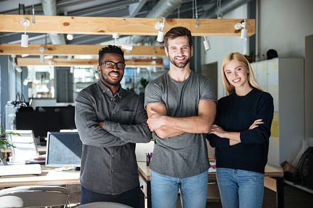 Smiling young colleagues standing with arms crossed, a Business Photo by Dean Drobot