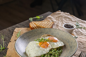Fried eggs with green peas puree, a Photo by Grafvision photography