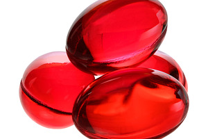Several red gel capsules or vitamins on an isolated background., a Health & Medical Photo by ndanko