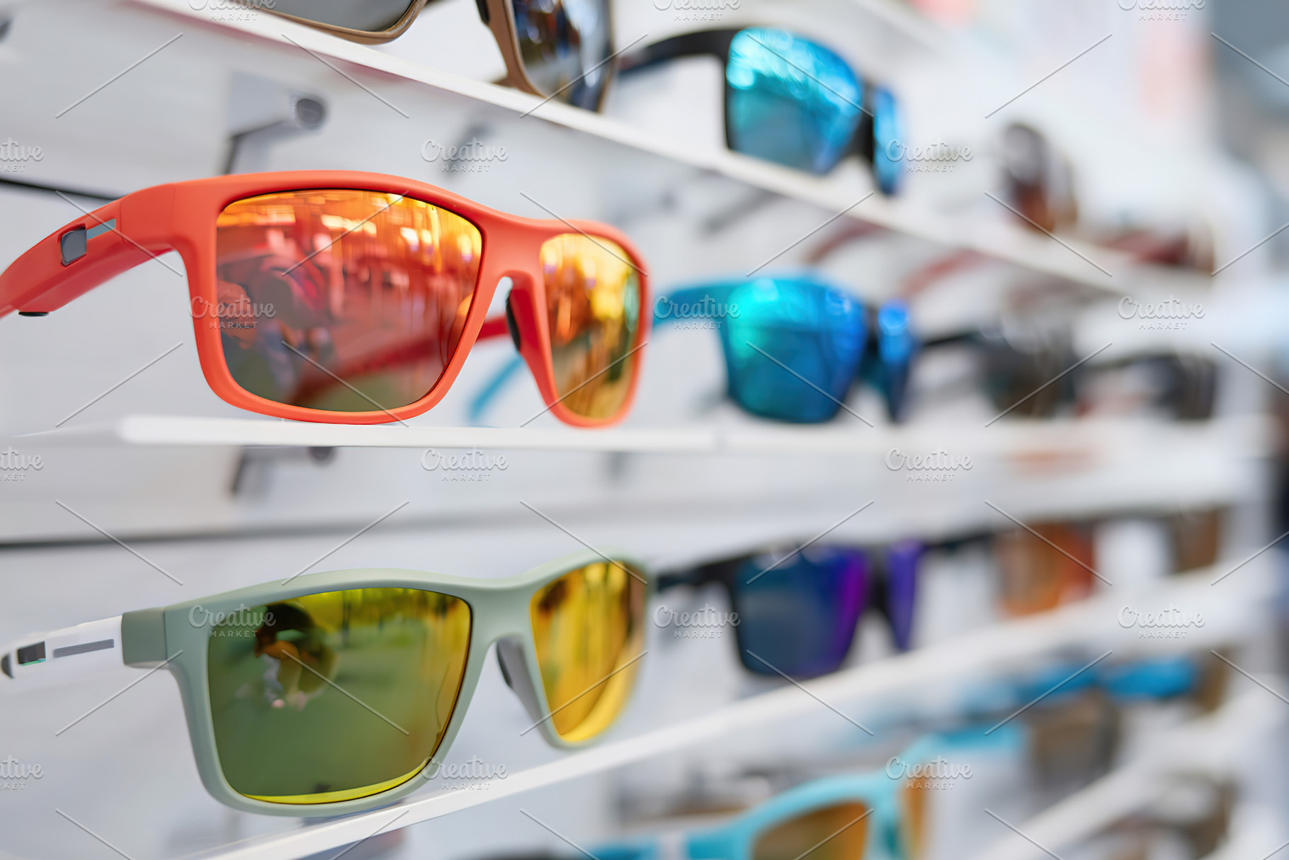 Colorful sunglasses displayed on a rack in a retail store during daylight hours, a Photo by AlyaAnd