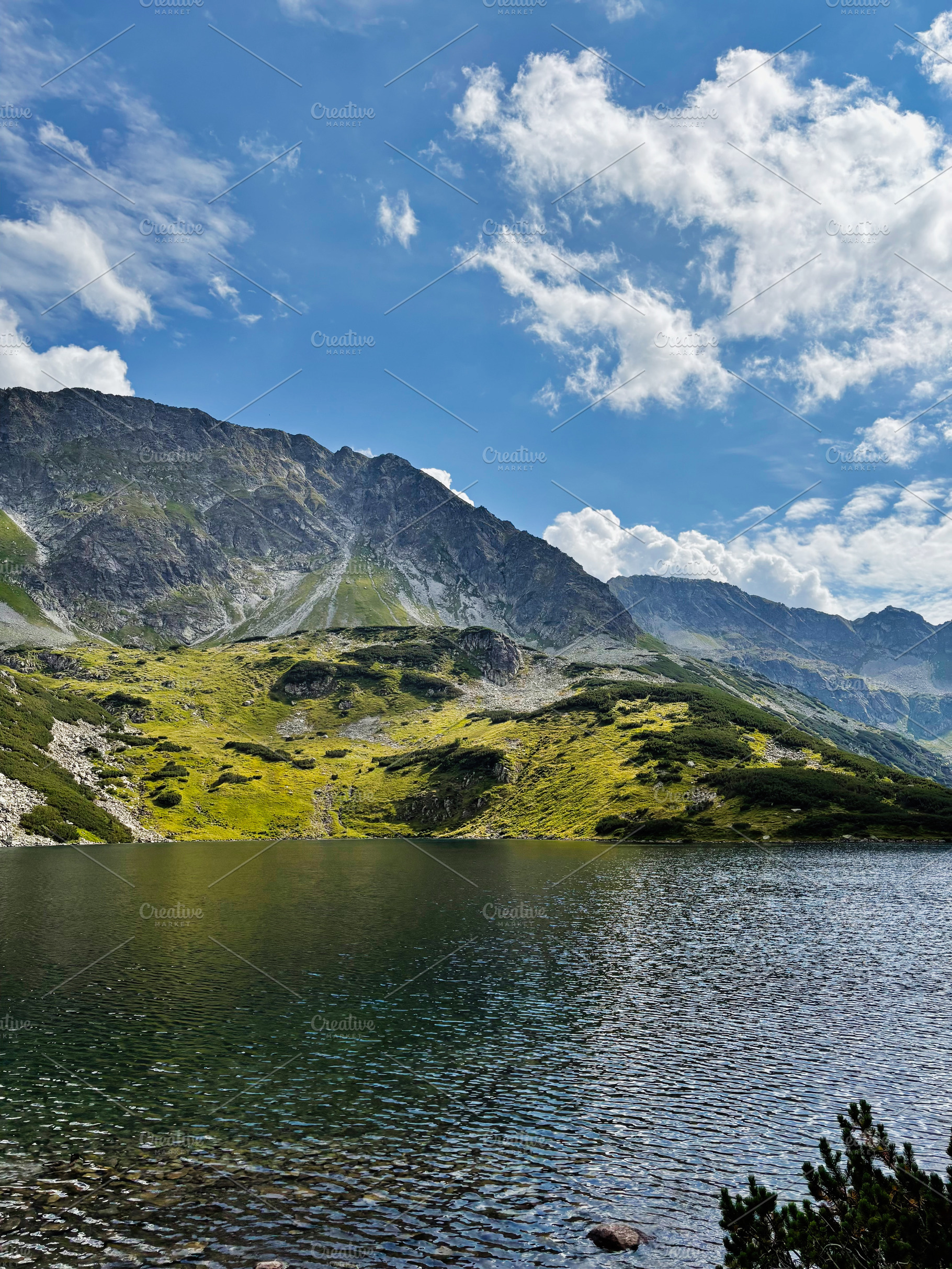 Scenic alpine lake in Zakopane, Poland with rugged mountains and bright blue sk, a Nature Photo by AS photostudio