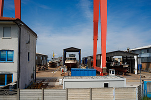Large yacht being lifted by crane in a shipyard., an Architecture Photo by Bepslabor