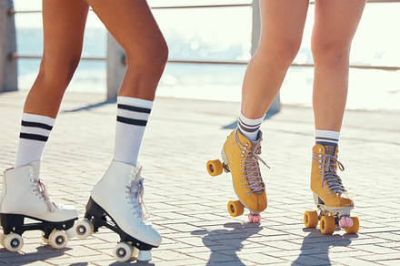 Roller skates or gen z friends on promenade for summer fun holiday activity or travel outdoor. Cool, trendy or funky women skating legs in quad skating or rollerblades with sunshine, beach and ground, a Photo by Peopleimages.com