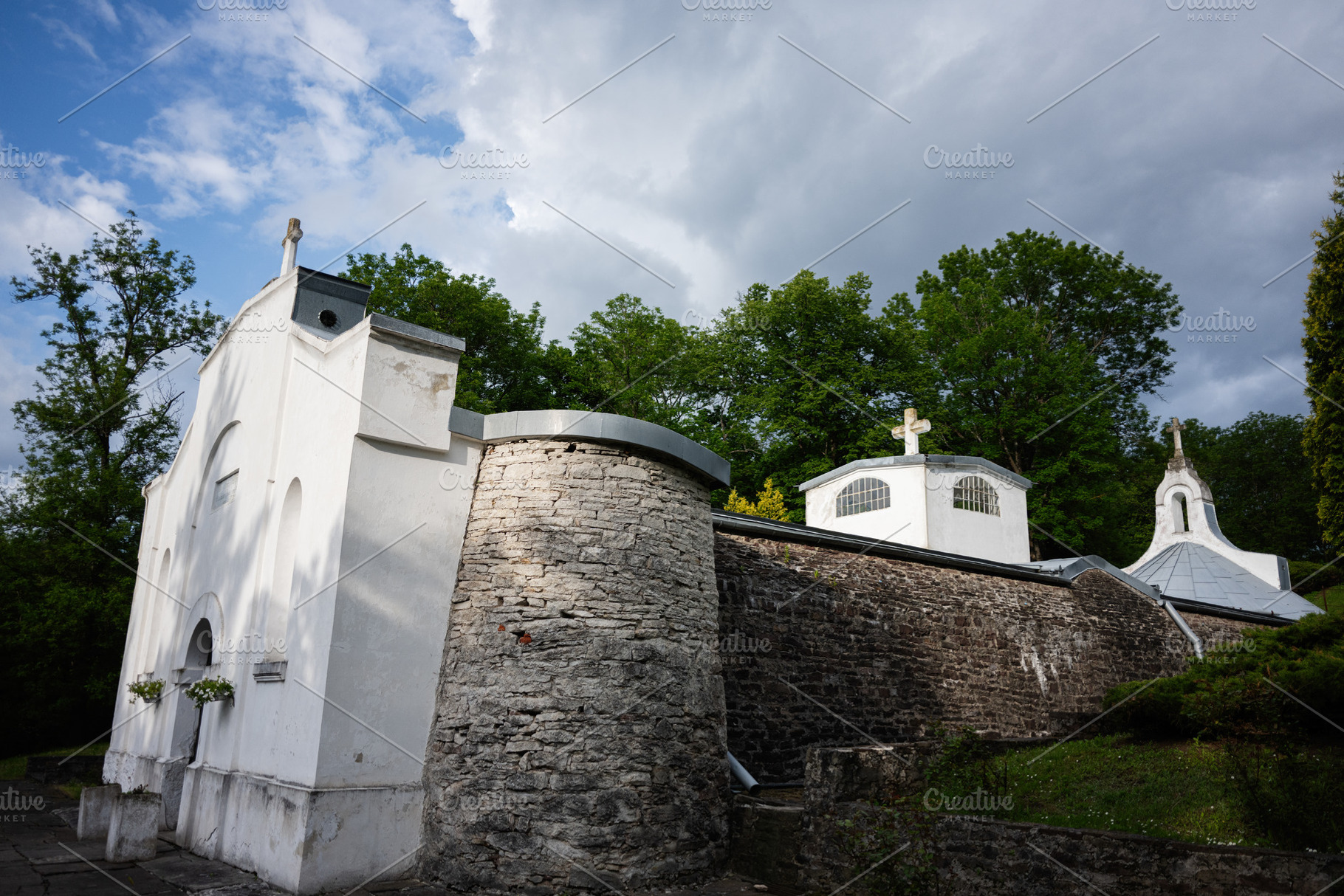 Small Catholic columbarium surrounded by nature on a cloudy day in Yazlovets, U, a Photo by AS photostudio