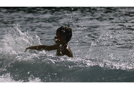 Boy swims in sea with waves, a Person Photo by Media Whale Stock