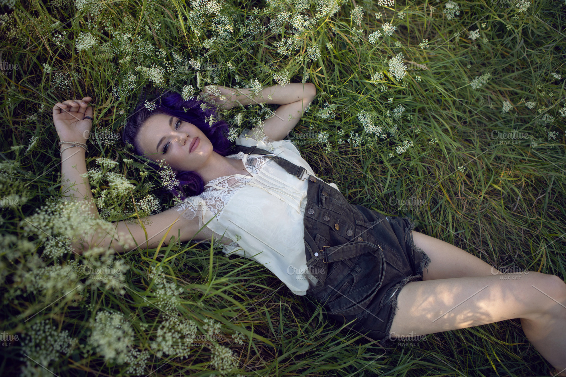 portrait of a teenage girl with purple hair and an earring in her nose lying in, a Person Photo by SaulichPhoto