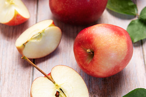 Red apples and slices on light wood background, a Food & Drink Photo by Olena Rudo