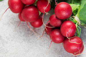 Fresh red radish bunch with green leaves on concrete, a Food & Drink Photo by Olena Rudo