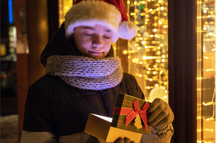 Boy in Santas hat with gifts box, a Person Photo by Jan Jack Russo Media