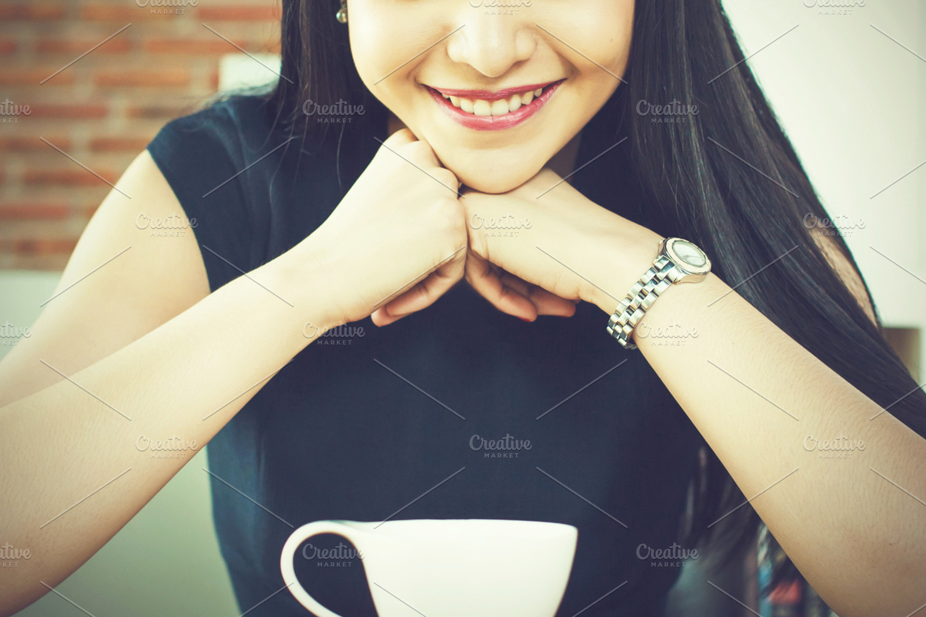 Asian woman looking at coffee cup and loving it in modern cafe featuring, a Person Photo by Twinster Photo