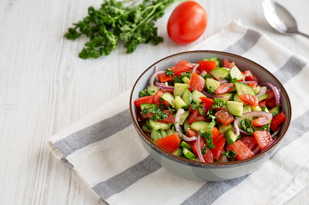 Homemade Mediterranean Cucumber Tomato Salad in a Bowl, side vie, a Food & Drink Photo by LiudmylaChuhunova