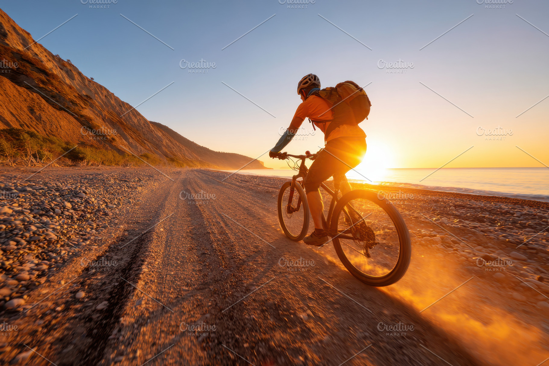Cyclist on a beach path at sunset, a Person Photo by AlyaAnd