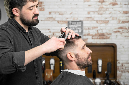 Barber cutting hair with scissors to a handsome young man ., a Person Photo by david.herraez.calzad