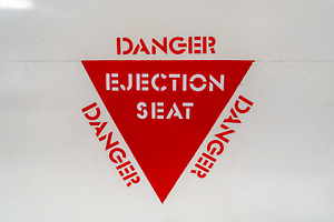 Ejection seat warning sign on an old aircraft fuselage close-up, a Background Photo by GoodGoods