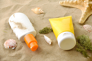 Sunscreen Bottles on Sandy Beach, a Holiday Photo by Davizro's Market